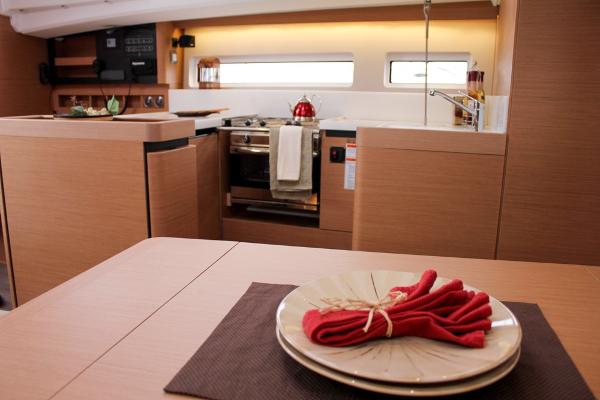 Slide: The Image of 2024 Jeanneau Sun Odyssey 440 interior kitchen with modern design and elegant dining setup. - 39