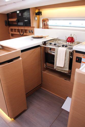 Slide: The Image of 2024 Jeanneau Sun Odyssey 440 yacht kitchen with modern appliances and sleek wood finish. - 46