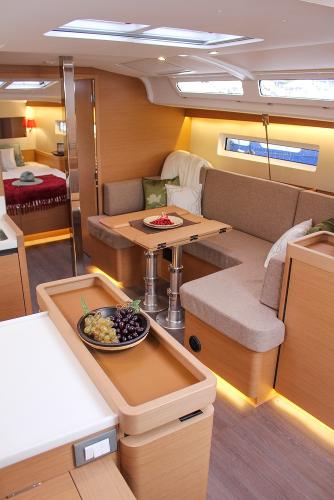 Slide: The Image of 2024 Jeanneau Sun Odyssey 440 interior with modern seating, dining area, and natural lighting. - 5