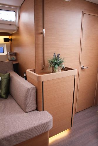Slide: The Image of 2024 Jeanneau Sun Odyssey 440 interior with modern wood finish and cozy seating area. - 8