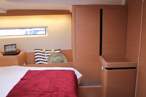 Slide: The Image of 2024 Jeanneau Sun Odyssey 440 cabin interior with wooden finish and cozy bedding. - 9