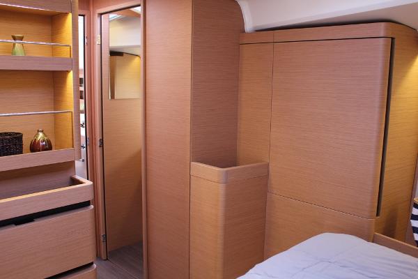 Slide: The Image of Interior of 2024 Jeanneau Sun Odyssey 490 yacht, featuring modern wood cabinetry and shelving. - 4