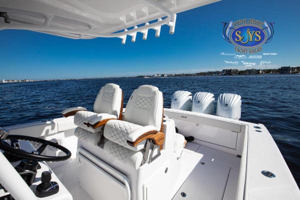Slide: The Image of 2024 Jupiter 34 boat interior with luxurious seating and multiple outboard engines on a calm sea. - 21