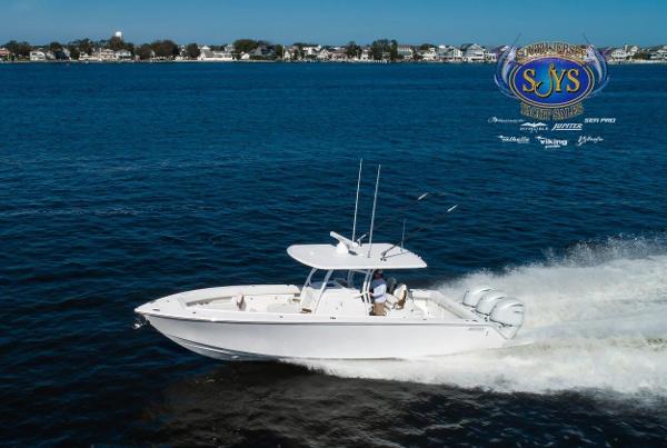 Slide: The Image of 2024 Jupiter 34 boat cruising on blue water near a coastal town. - 3