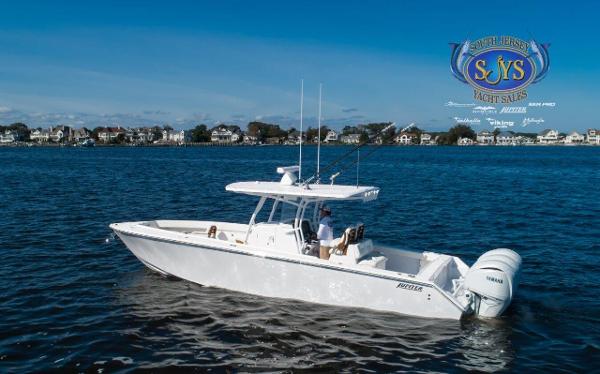 Slide: The Image of 2024 Jupiter 34 boat cruising on a calm lake near a residential area. - 31
