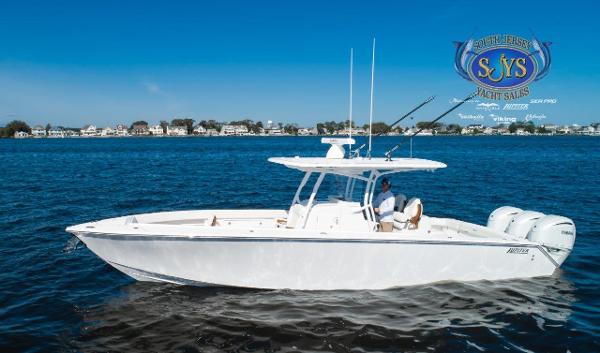 Slide: The Image of 2024 Jupiter 34 boat cruising on a calm lake near a residential area. - 7