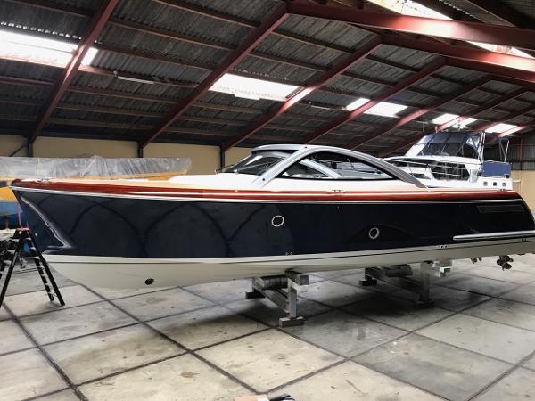 Slide: The Image of 2025 Keizer 42 boat in a warehouse, sleek design, black and white hull. - 0