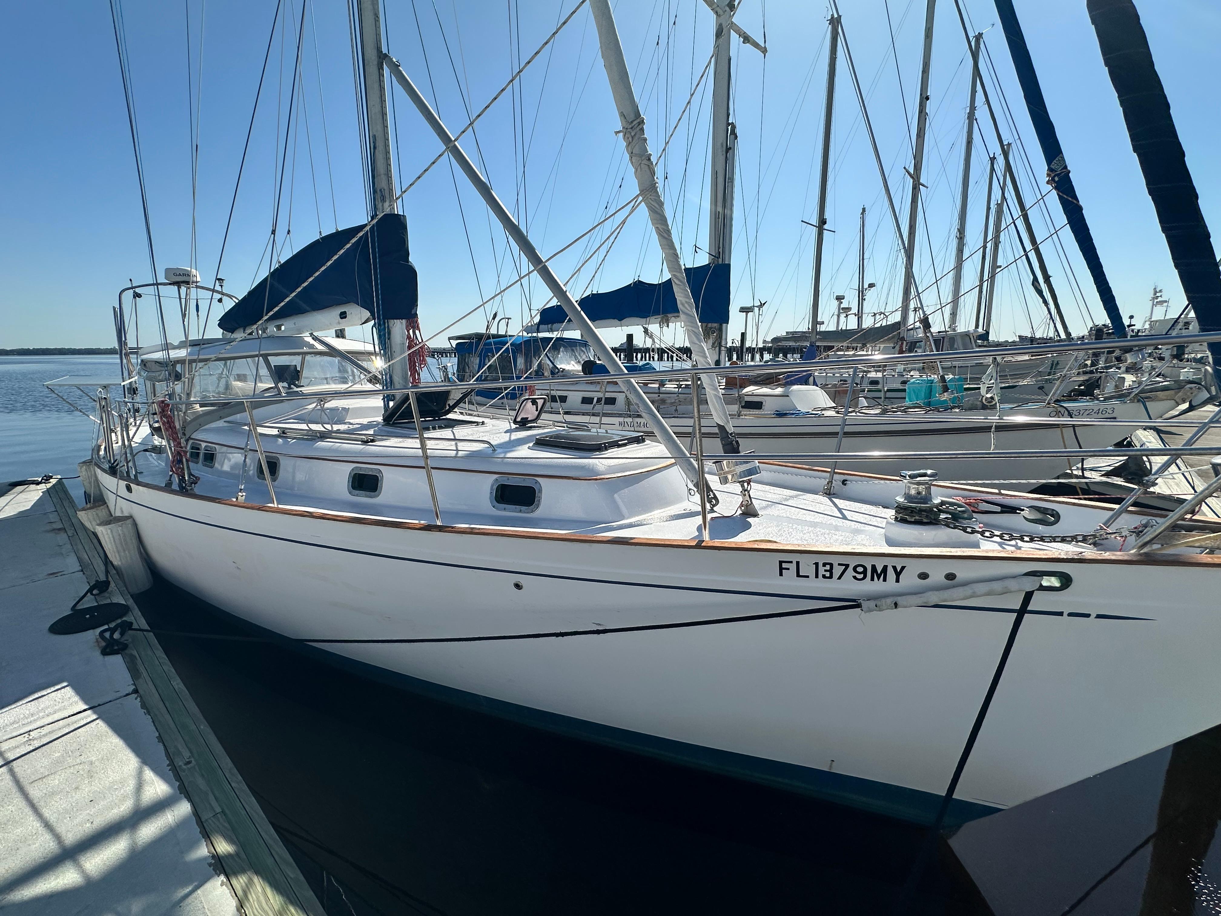 Slide: The Image of 1981 Kelly Peterson 44 sailboat docked at marina, clear sky background. - 0