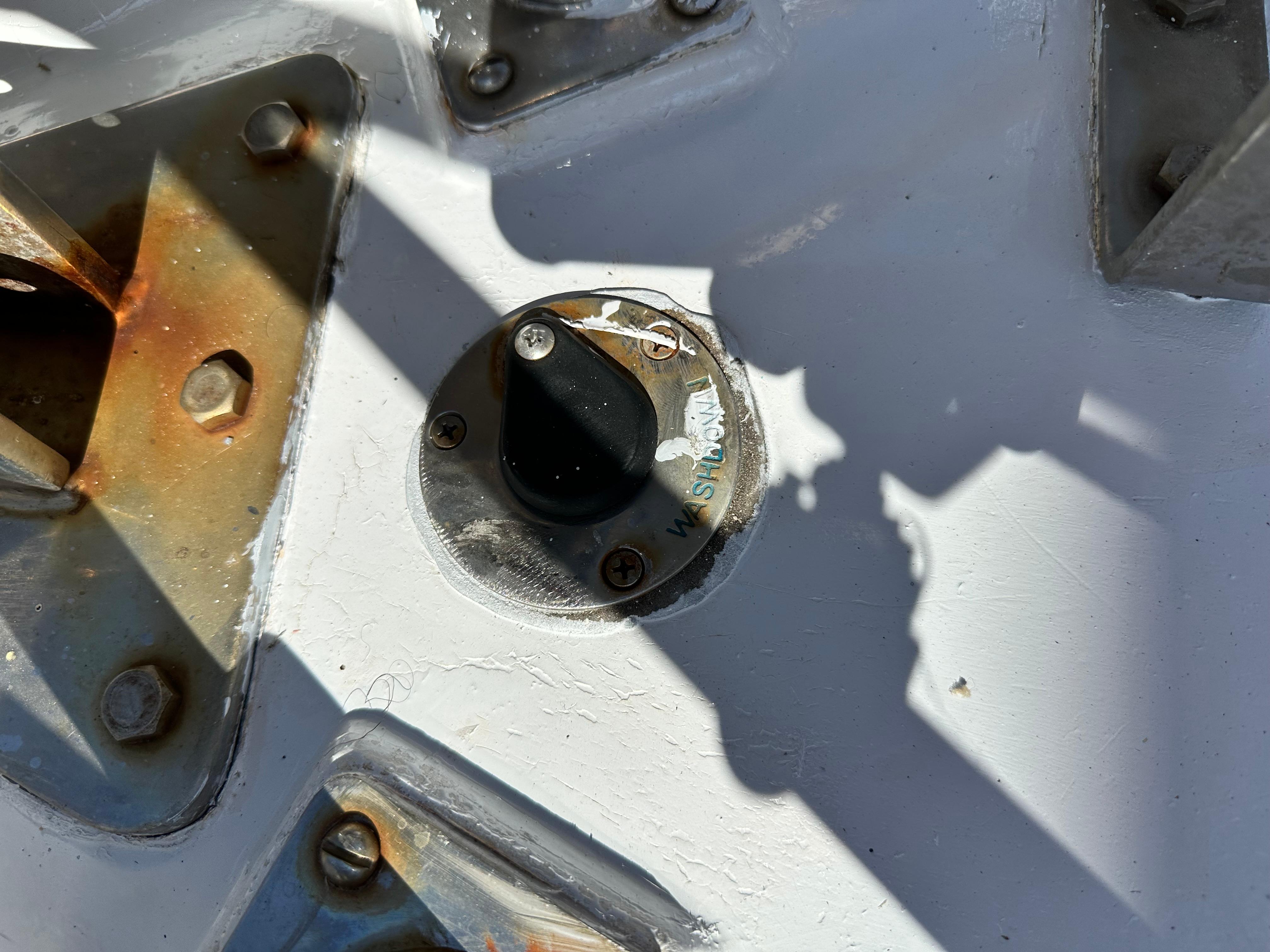 Slide: The Image of Close-up of a 1981 Kelly Peterson 44 deck fitting with rusted bolts and shadows. - 9