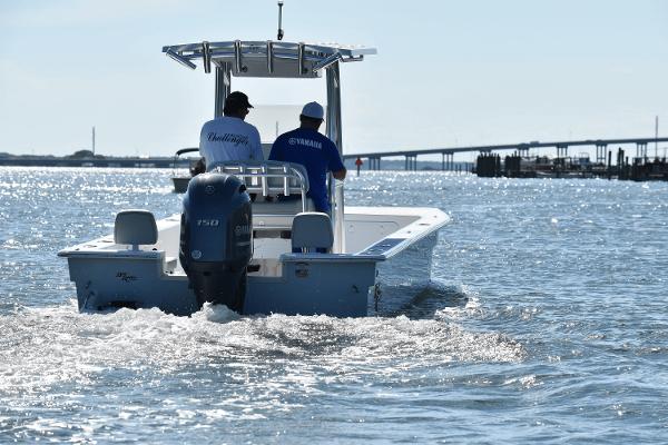 Slide: The Image of Two people on a 2025 KenCraft 2460 Bay Rider Skiff boat in open water. - 1