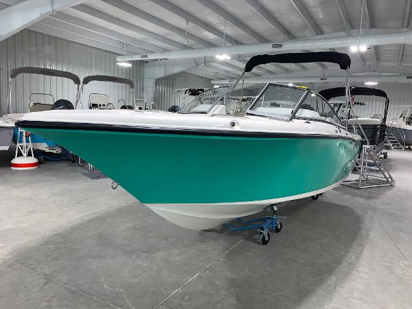 Slide: The Image of 2024 Key West 203 DFS boat in showroom, teal hull, black bimini top. - 1