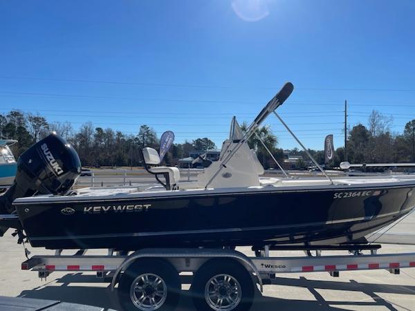 Slide: The Image of 2023 Key West 210 Bay Reef boat on a trailer with Suzuki outboard motor. - 2