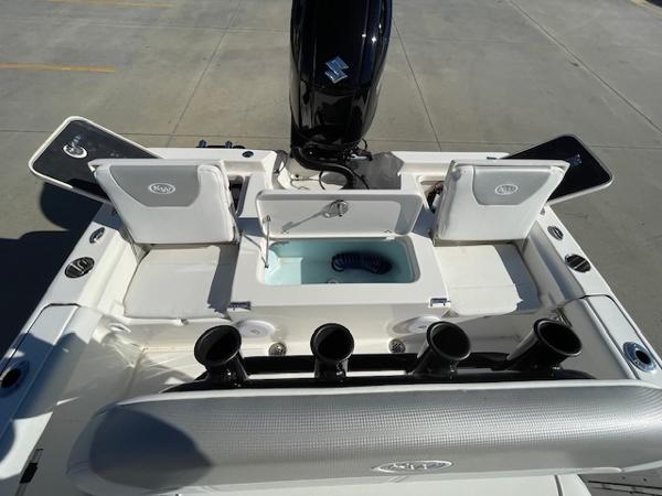 Slide: The Image of 2023 Key West 210 Bay Reef boat with open storage compartments and motor. - 7