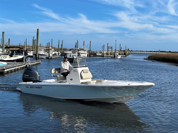 Slide: The Image of 2025 Key West 210 Bay Reef boat cruising in a marina under a clear blue sky. - 1