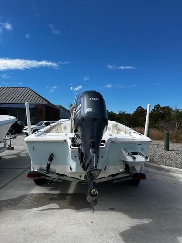 Slide: The Image of 2025 Key West 210 Bay Reef boat with outboard motor, parked outdoors. - 11