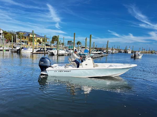 Slide: The Image of 2025 Key West 210 Bay Reef boat cruising in a sunny marina. - 2