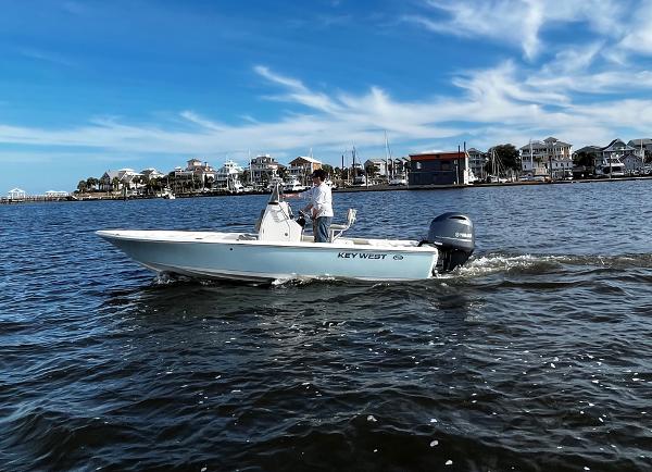 Slide: The Image of 2025 Key West 210 Bay Reef boat cruising on a sunny day near coastal homes. - 30