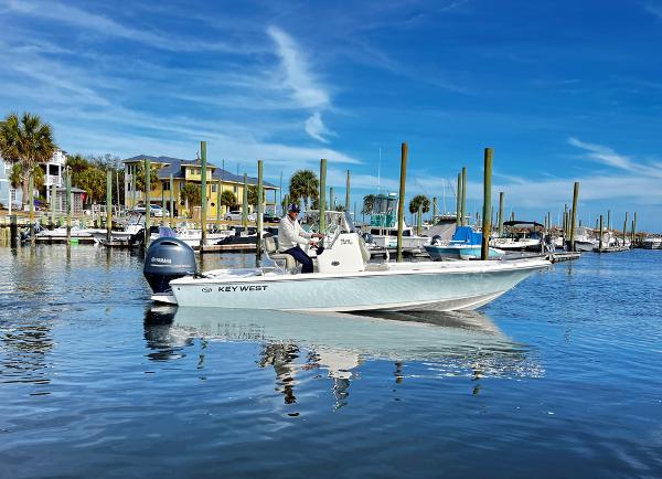Slide: The Image of 2025 Key West 210 Bay Reef boat on calm marina waters under blue sky. - 4
