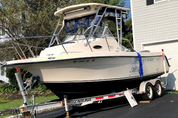 Slide: The Image of 2005 Key West 2300 WA boat on a trailer in a driveway. - 1