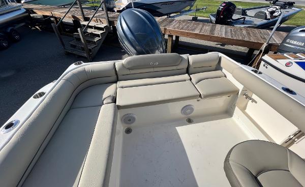 Slide: The Image of 2024 Key West 239 DFS boat interior with cushioned seating and outboard motor. - 10