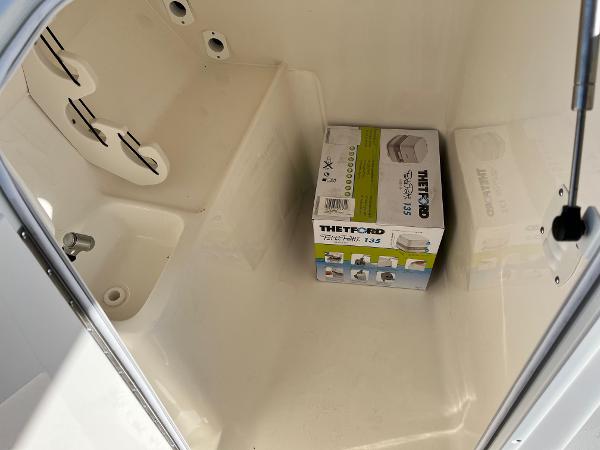 Slide: The Image of 2024 Key West 239 DFS storage compartment with Thetford portable toilet box. - 19