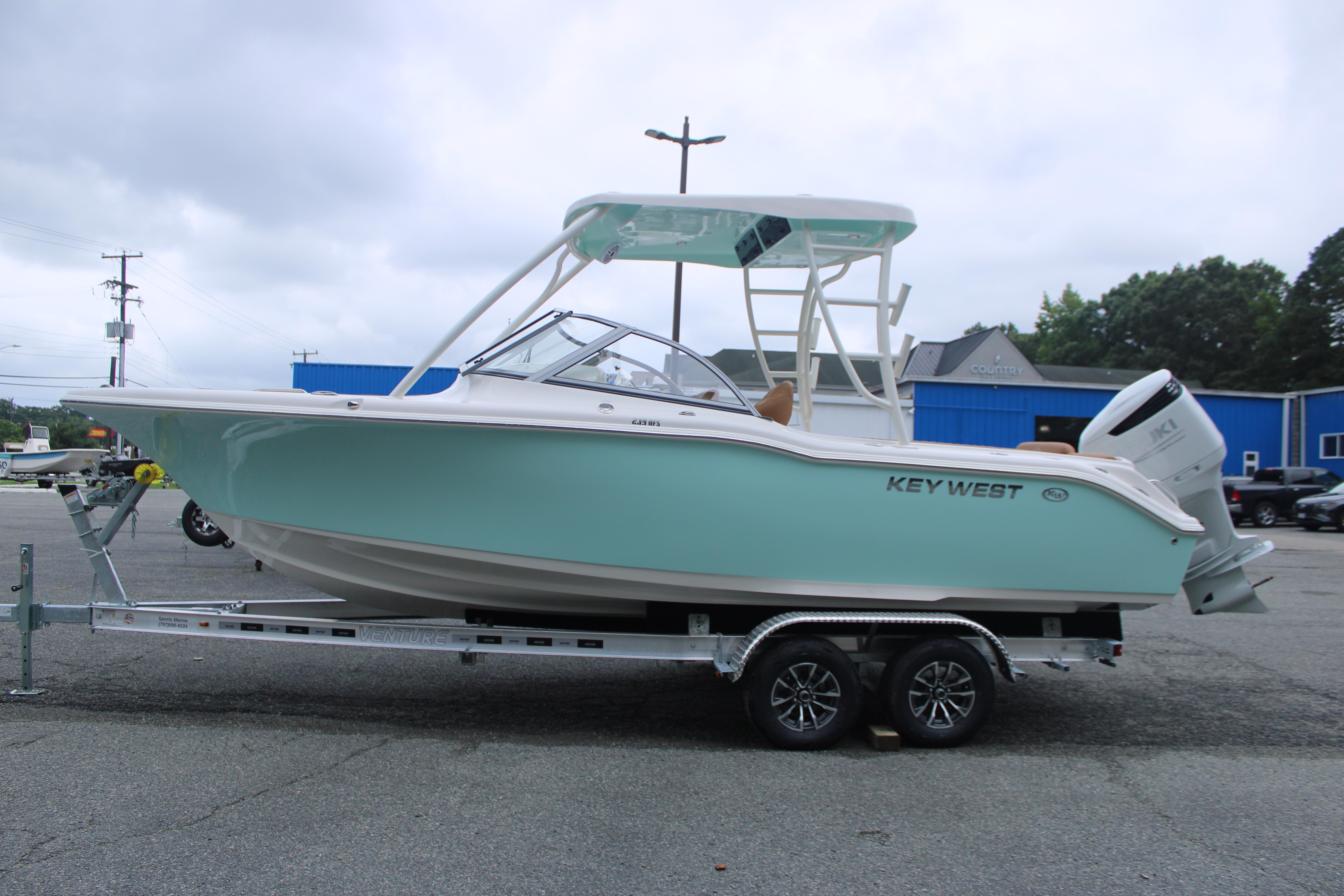 Slide: The Image of 2026 Key West 239 DFS boat on trailer, light blue hull, parked outdoors. - 0