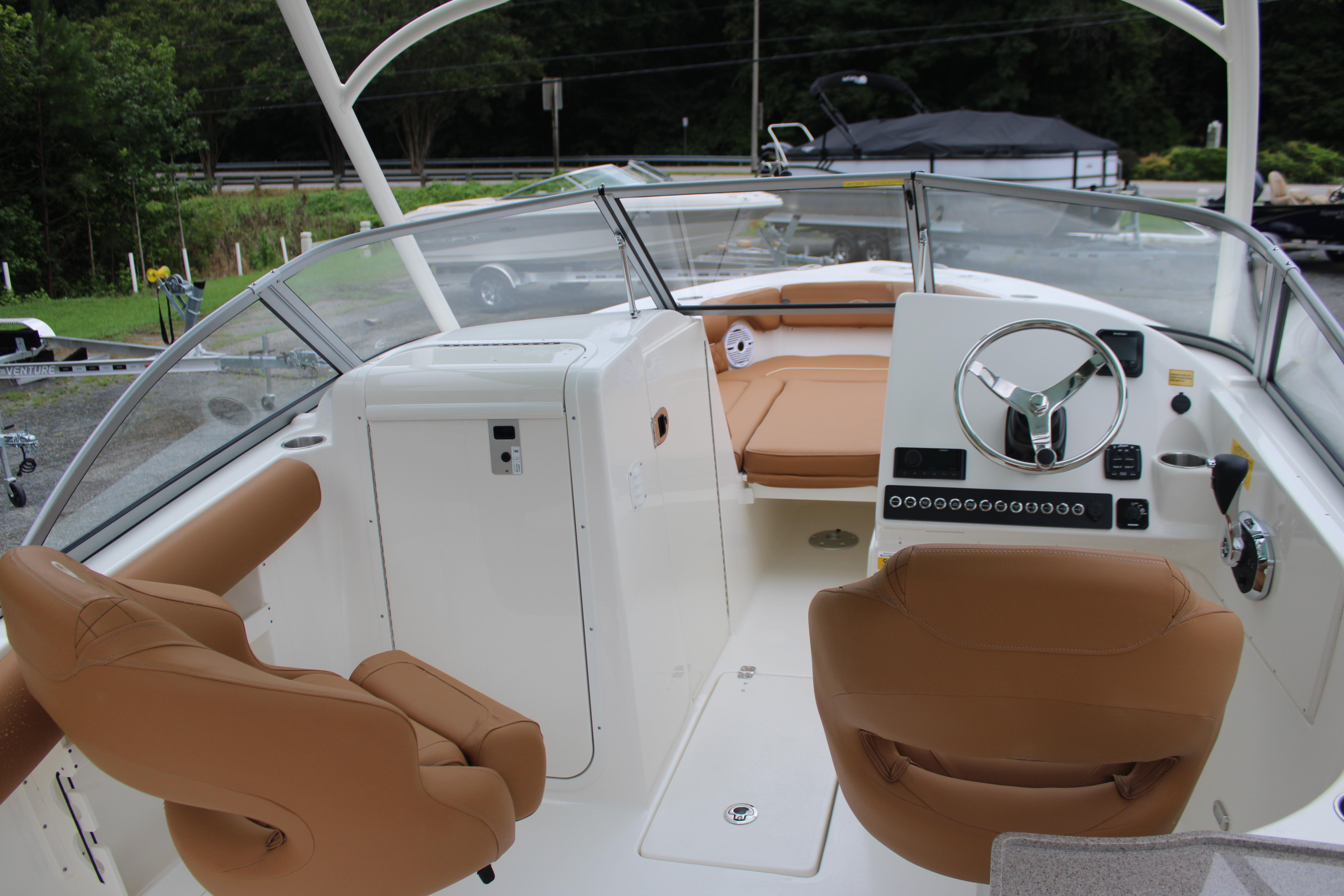 Slide: The Image of 2026 Key West 239 DFS boat interior with tan seats and modern steering console. - 12