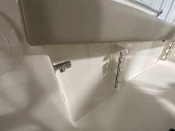 Slide: The Image of 2024 Key West 244 CC boat interior detail showing storage compartment and latch. - 28