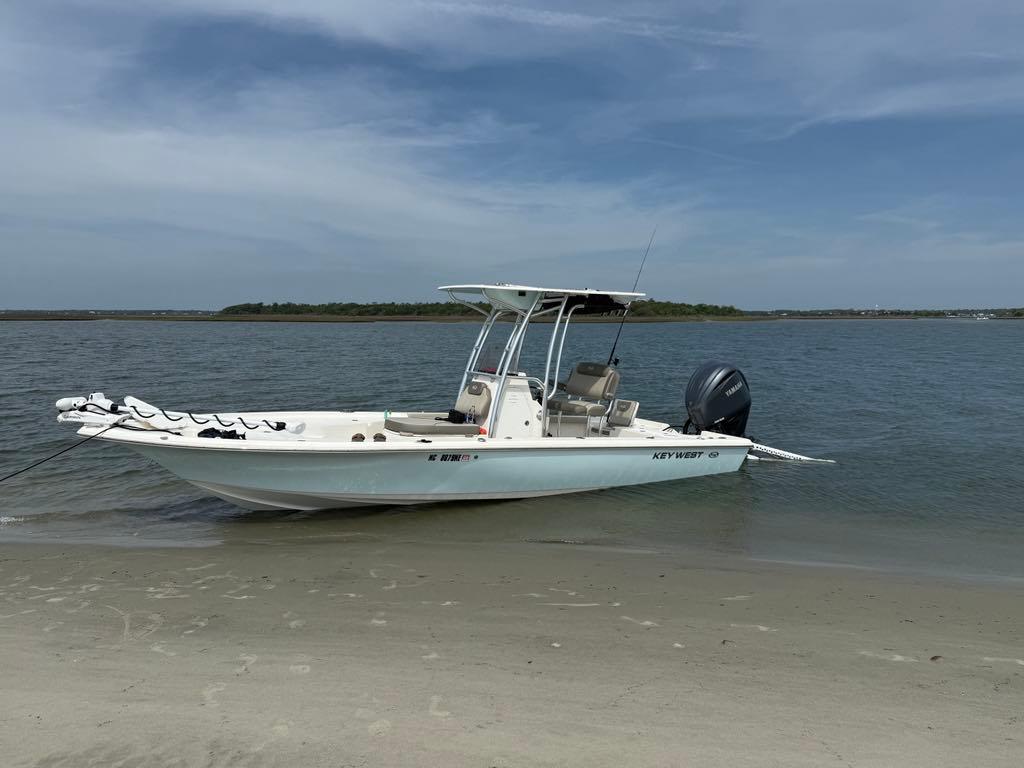 The Image of 2023 Key West 250 Bay Reef boat anchored on sandy shore, calm water background. - 1