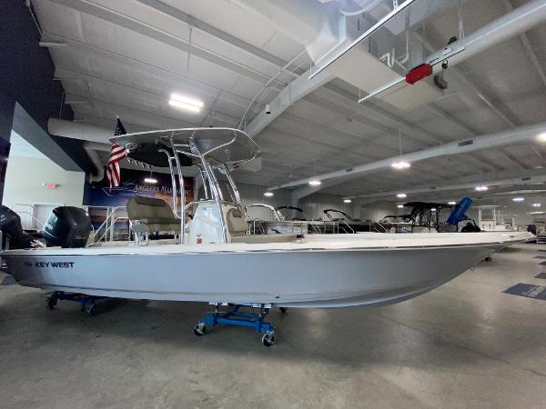Slide: The Image of 2024 Key West 250 Bay Reef boat displayed in a showroom. - 0