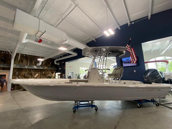 Slide: The Image of 2024 Key West 250 Bay Reef boat displayed indoors with American flag. - 1
