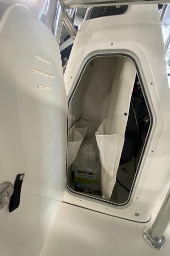 Slide: The Image of 2024 Key West 250 Bay Reef storage compartment with open door. - 24