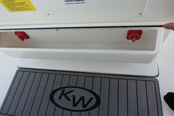 Slide: The Image of 2024 Key West 263 FS boat storage compartment with red handles and KW logo mat. - 44