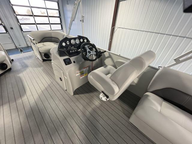 Slide: The Image of 2024 Landau Island Breeze 212 Sport Rear Lounge Tri-Log interior with steering console and seating. - 13