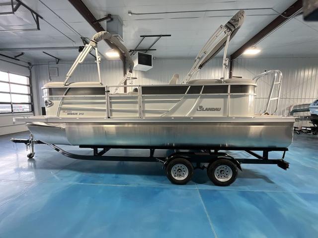 Slide: The Image of 2024 Landau Island Breeze 212 Sport Rear Lounge Tri-Log pontoon boat in showroom. - 2