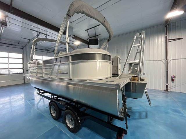 Slide: The Image of 2024 Landau Island Breeze 212 Sport Rear Lounge Tri-Log pontoon boat in a showroom. - 3
