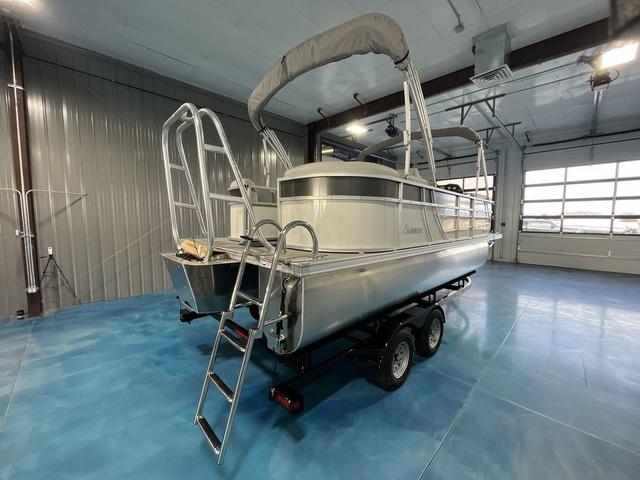 Slide: The Image of 2024 Landau Island Breeze 212 Sport Rear Lounge Tri-Log pontoon boat in a showroom. - 5
