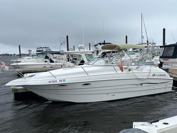 Slide: The Image of 2002 Larson 254 Cabrio boat docked at marina. - 0