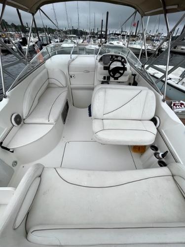 Slide: The Image of 2002 Larson 254 Cabrio boat interior with white seating and steering console. - 4