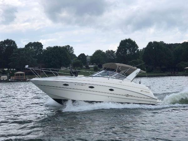 Slide: The Image of 2003 Larson 330 CABRIO cruising on a lake with trees in the background. - 0