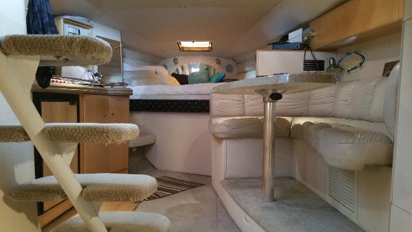 Slide: The Image of Interior of a 2003 Larson 330 Cabrio boat with cozy seating and a small kitchen area. - 10