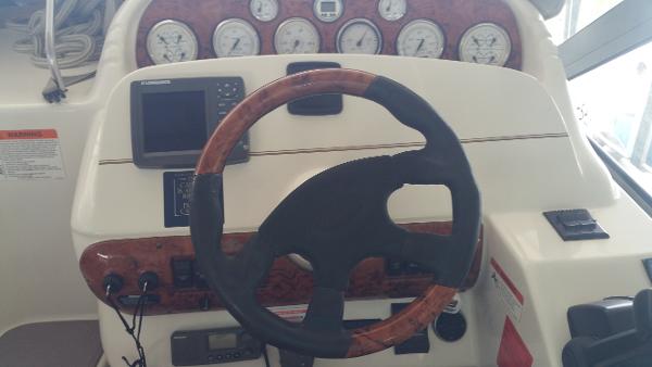 Slide: The Image of 2003 Larson 330 CABRIO boat helm with steering wheel and instrument panel. - 12