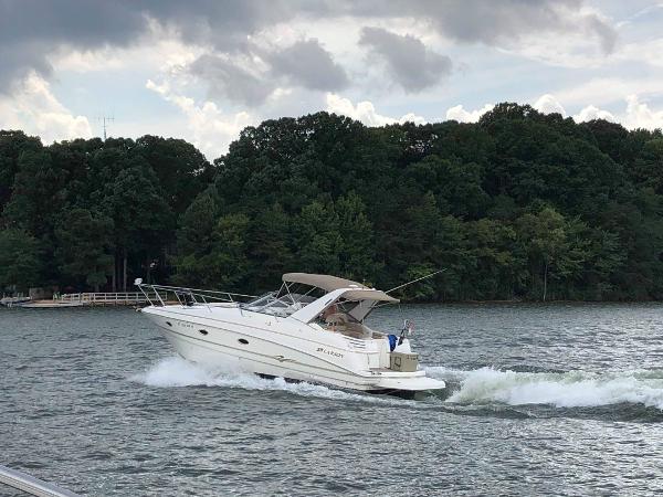 Slide: The Image of 2003 Larson 330 Cabrio cruising on a lake with forested shoreline. - 15