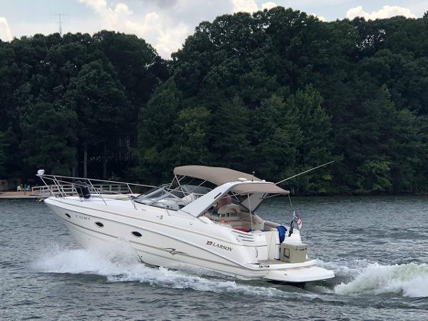 Slide: The Image of 2003 Larson 330 Cabrio cruising on a lake with forested shoreline. - 4