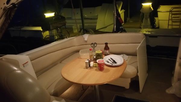 Slide: The Image of 2003 Larson 330 CABRIO boat interior with dining table setup at night. - 5