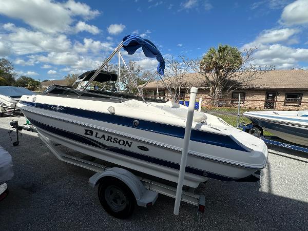 Slide: The Image of 2006 Larson LXi 208 boat on a trailer under a blue sky. - 1
