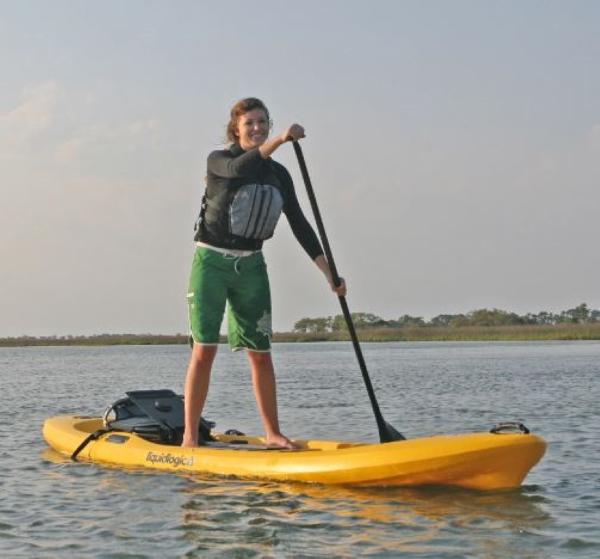 Slide: The Image of Person paddleboarding on a 2023 Liquidlogic Versa Board in calm waters. - 1