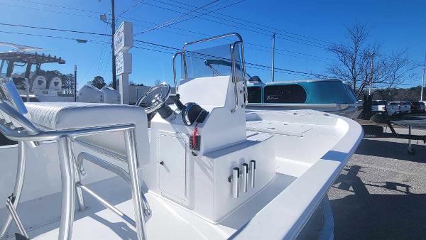 Slide: The Image of 2024 Lookout Skiff Bay 19 boat console and seating in a marina. - 12