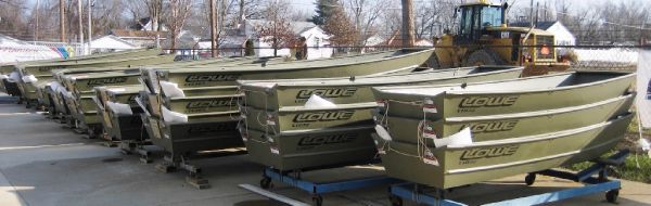 Slide: The Image of Row of 2025 Lowe 1448 Jon boats on display outdoors. - 2
