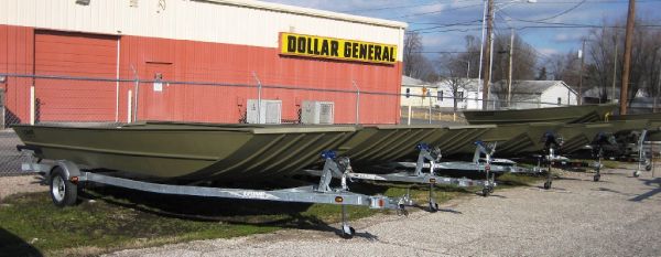 Slide: The Image of 2025 Lowe 1448 Jon boats on trailers near Dollar General store. - 3
